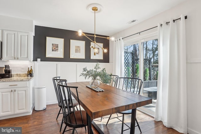 dining room featuring a chandelier, dark wood-type flooring, and visible vents