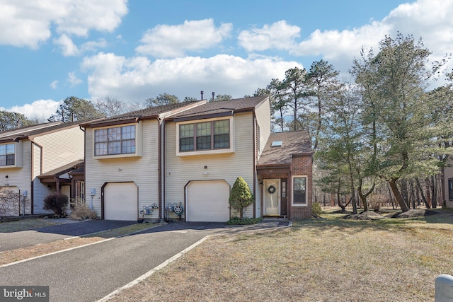 multi unit property with a front lawn, driveway, a shingled roof, and an attached garage