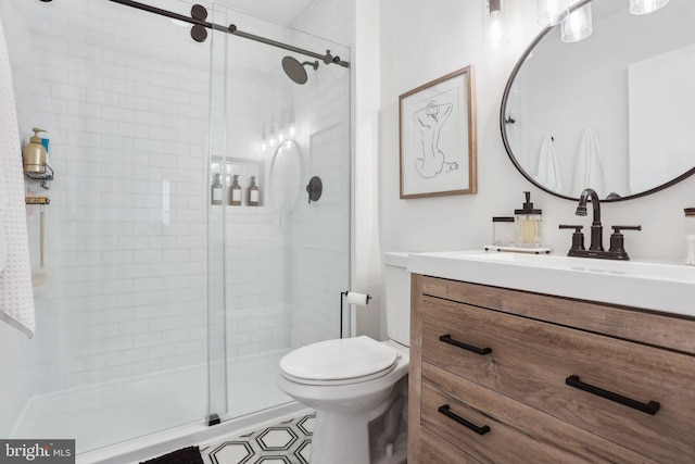 full bath featuring toilet, a stall shower, and vanity