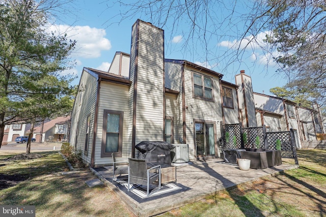 back of property featuring a chimney and a patio area