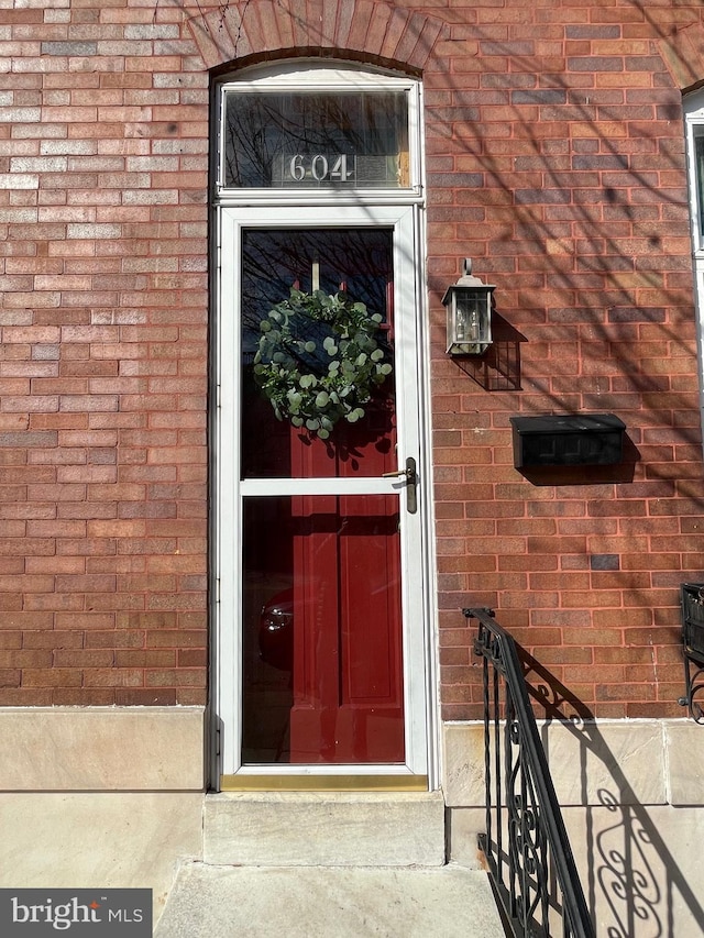 view of exterior entry with brick siding