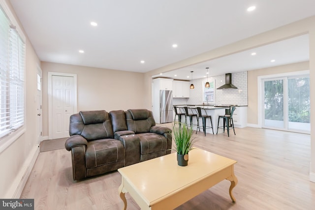 living room featuring light wood-type flooring, baseboards, and recessed lighting
