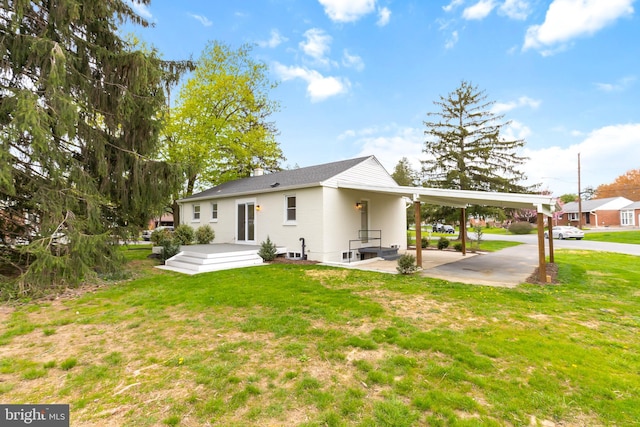 rear view of property with a yard and a carport