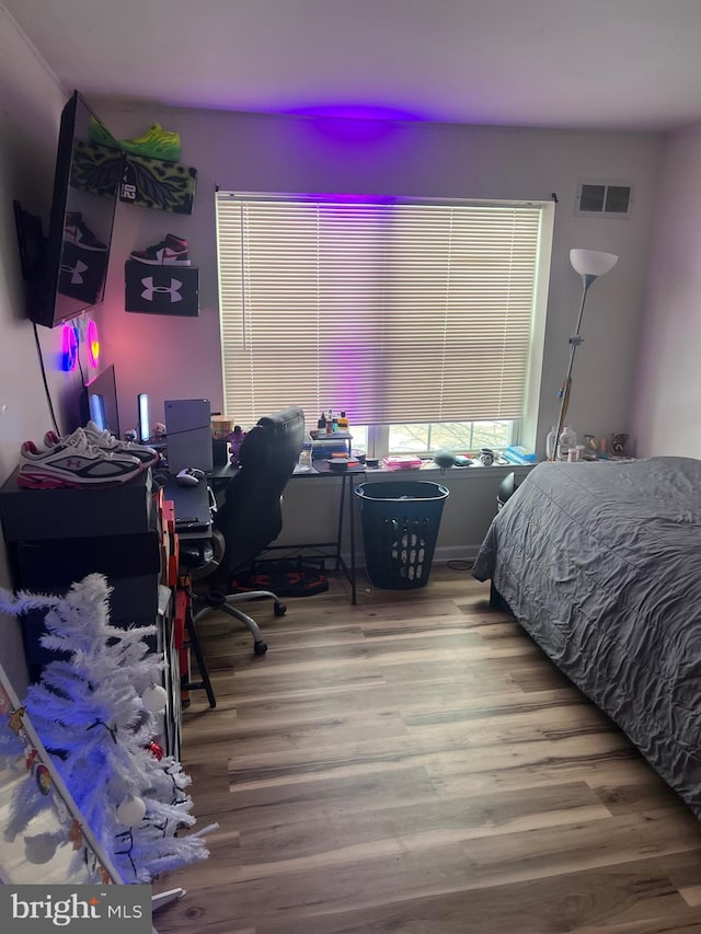 bedroom featuring visible vents and wood finished floors