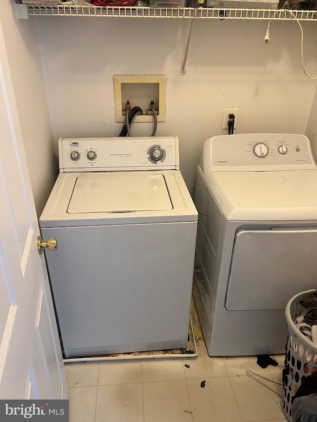 washroom featuring laundry area, separate washer and dryer, and tile patterned floors