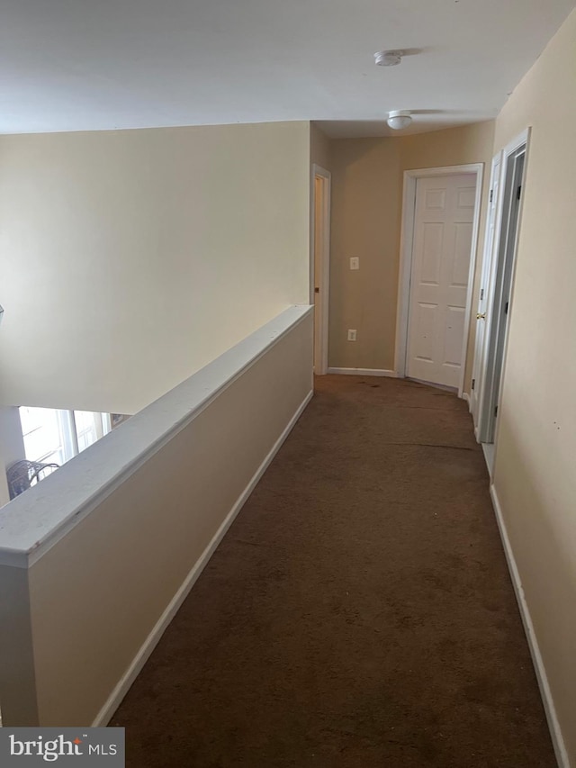 corridor with carpet floors and baseboards