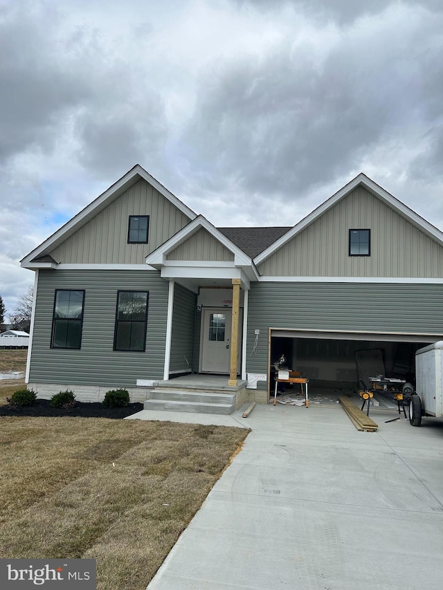 view of front of house featuring a garage, concrete driveway, and roof with shingles