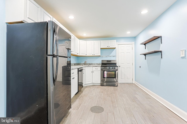 kitchen with light wood-style floors, white cabinetry, appliances with stainless steel finishes, and a sink