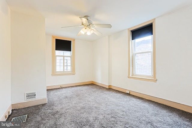 carpeted spare room featuring visible vents, ceiling fan, and baseboards