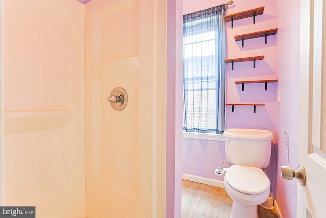 full bath with a shower, baseboards, toilet, and wood finished floors