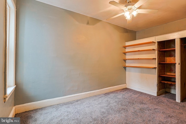 carpeted empty room with ceiling fan and baseboards