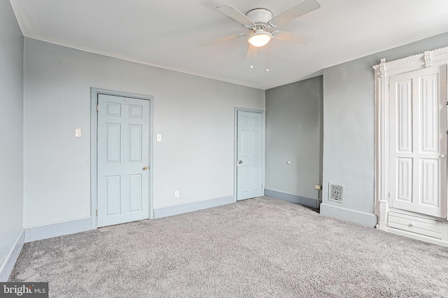 unfurnished bedroom with a ceiling fan, carpet flooring, visible vents, and baseboards
