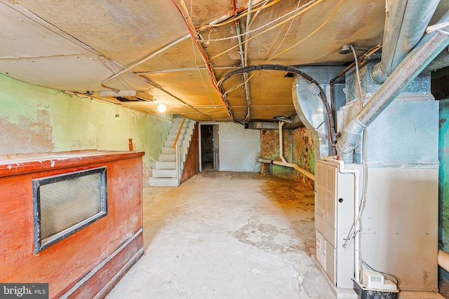 unfinished basement featuring heating unit and stairs