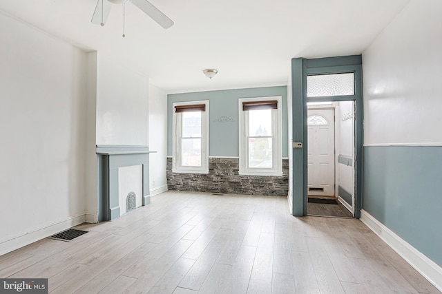 unfurnished living room with visible vents, ceiling fan, baseboards, and wood finished floors
