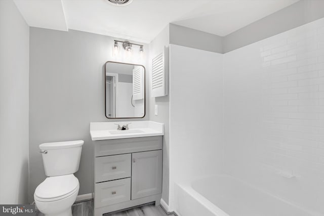 bathroom featuring baseboards, vanity, toilet, and wood finished floors