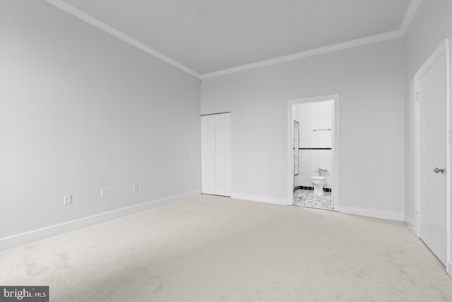 unfurnished bedroom featuring ornamental molding, light colored carpet, connected bathroom, and baseboards