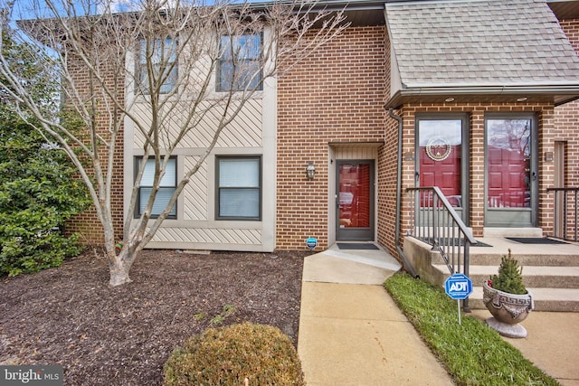 multi unit property with brick siding and roof with shingles