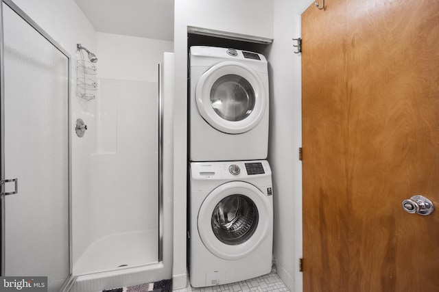 laundry area featuring stacked washer and dryer and tile patterned floors