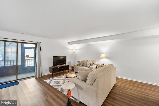 living area with wood finished floors, visible vents, and baseboards