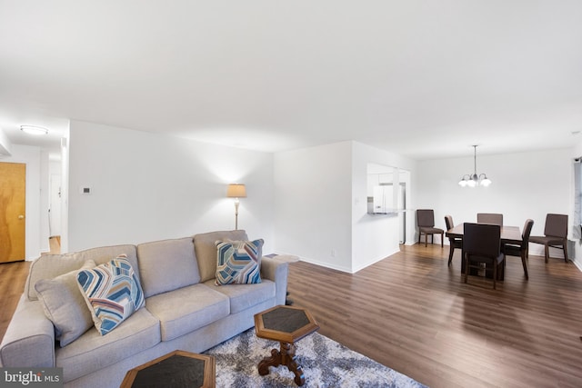 living room with a chandelier, wood finished floors, and baseboards