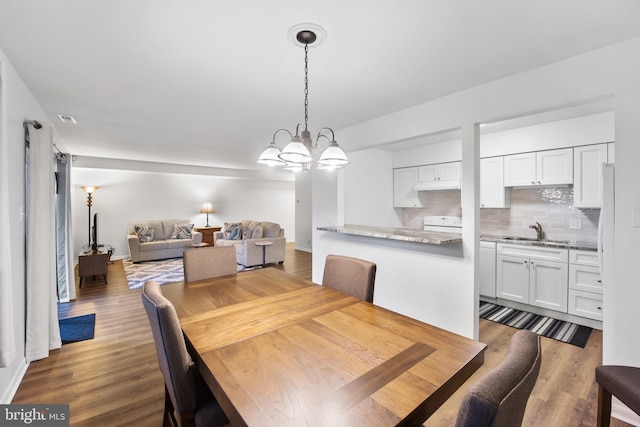 dining room with baseboards, dark wood-style flooring, and an inviting chandelier