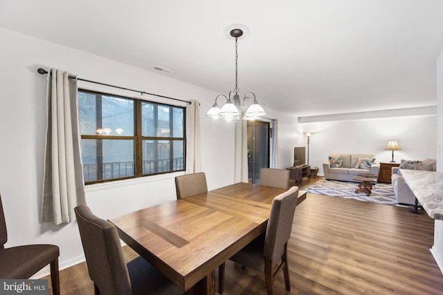 dining room with baseboards, visible vents, a chandelier, and dark wood-type flooring