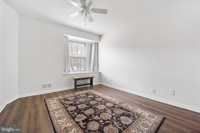 unfurnished room with ceiling fan, wood finished floors, visible vents, and baseboards