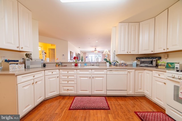 kitchen featuring white cabinetry, white appliances, light wood-style floors, and a sink