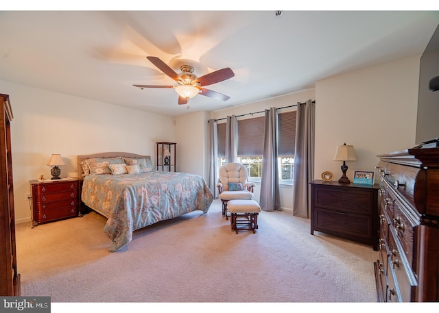 bedroom with a ceiling fan, baseboards, and light carpet