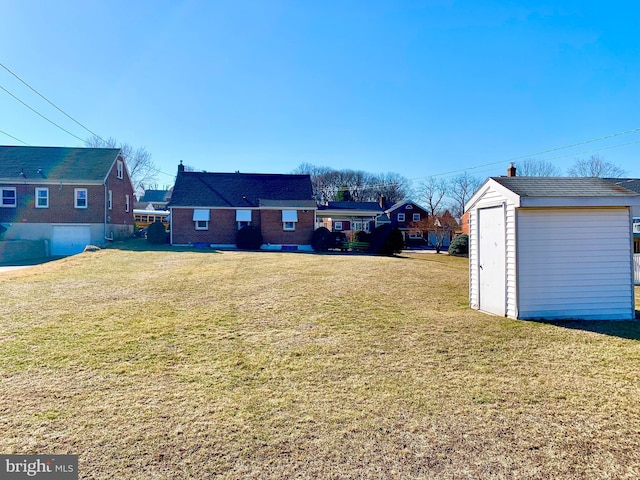 view of yard featuring an outdoor structure, a residential view, and a shed