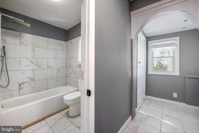 full bathroom featuring marble finish floor, bathing tub / shower combination, toilet, and baseboards