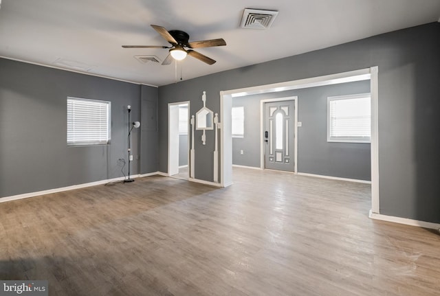 foyer entrance featuring baseboards, visible vents, and wood finished floors