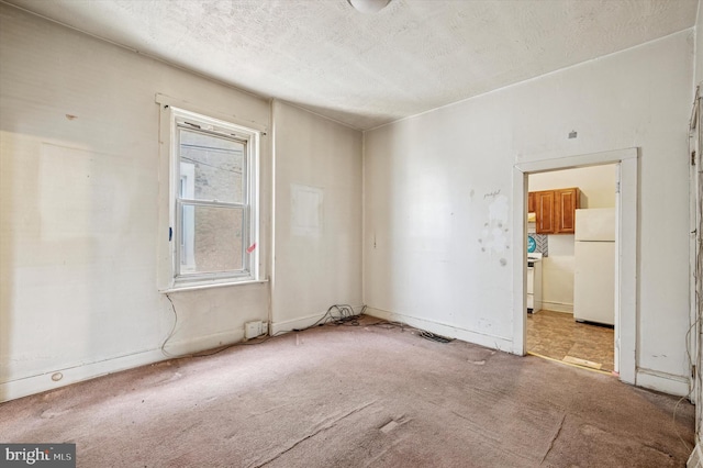 empty room with a textured ceiling and carpet