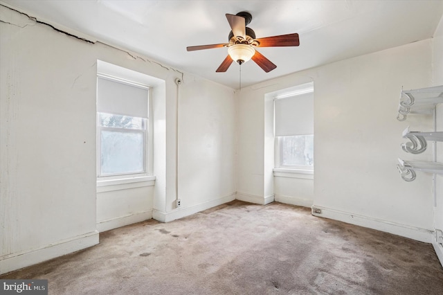 empty room with baseboards, plenty of natural light, carpet floors, and ceiling fan