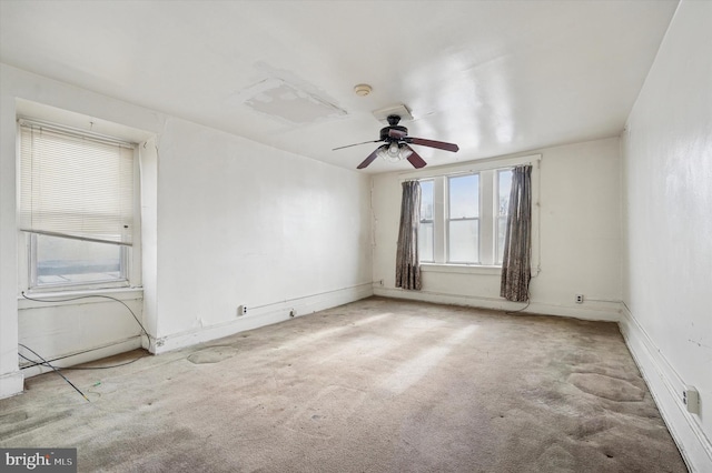 carpeted spare room with ceiling fan