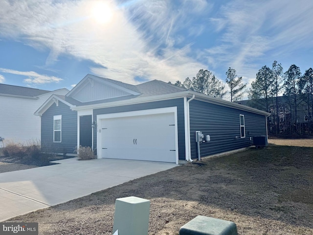 view of front of property featuring a garage, cooling unit, and driveway