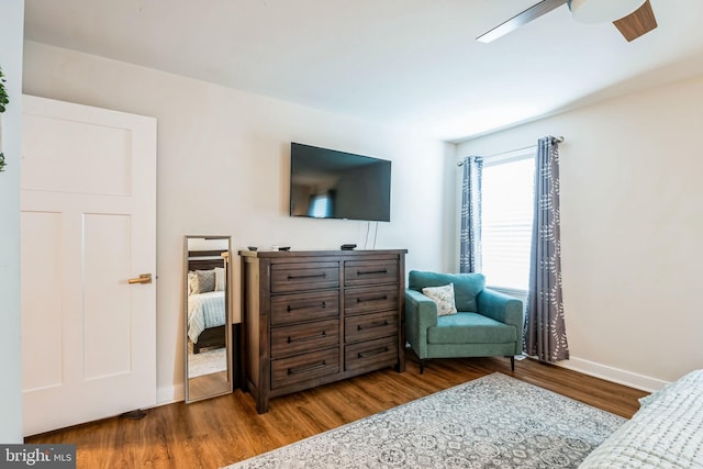 bedroom featuring ceiling fan, baseboards, and wood finished floors