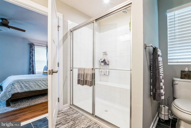 bathroom featuring ensuite bathroom, toilet, a ceiling fan, baseboards, and a shower stall