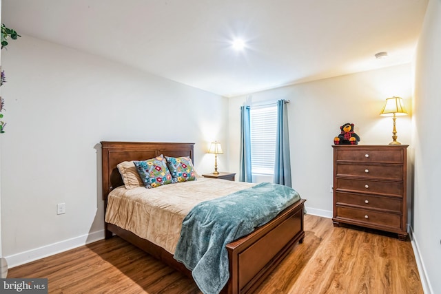 bedroom featuring light wood-style flooring and baseboards