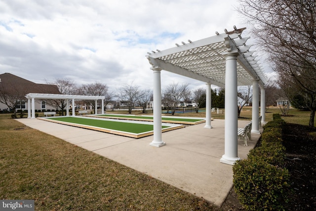 view of property's community featuring a lawn and a pergola