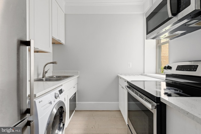 kitchen with stainless steel appliances, a sink, white cabinetry, tasteful backsplash, and washer / dryer