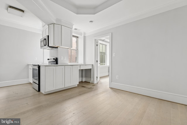 kitchen with stainless steel appliances, light countertops, white cabinetry, and light wood-style floors