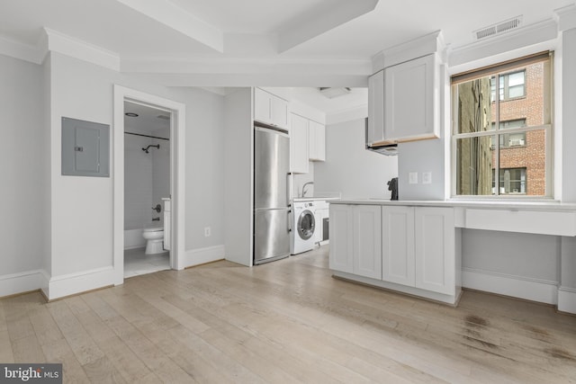 kitchen with electric panel, visible vents, washer / clothes dryer, freestanding refrigerator, and light wood-type flooring