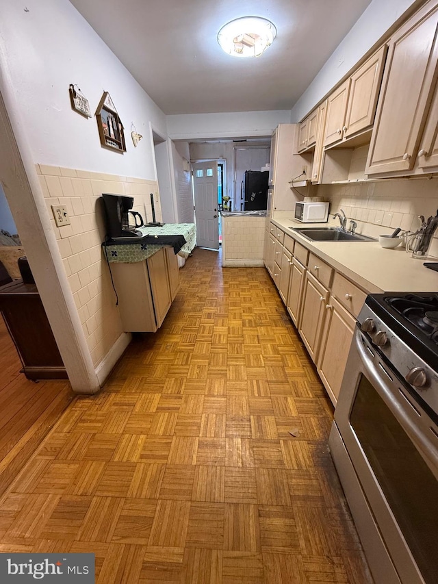332 Emerson St NW, Washington, DC 20011 - kitchen featuring light brown cabinets, a sink, light countertops, backsplash, and stainless steel range with gas stovetop