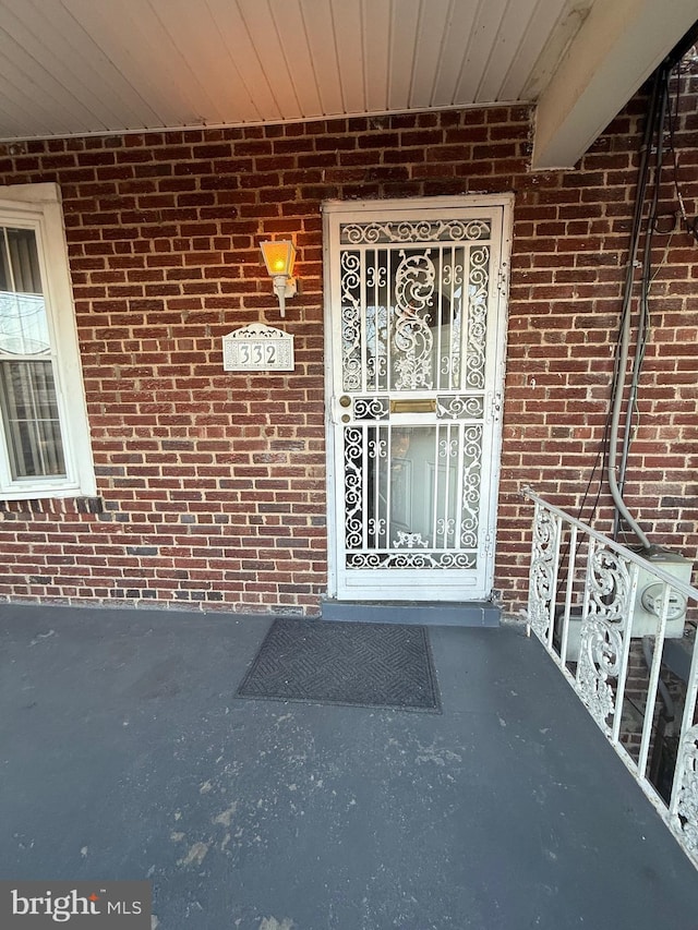 view of exterior entry with brick siding