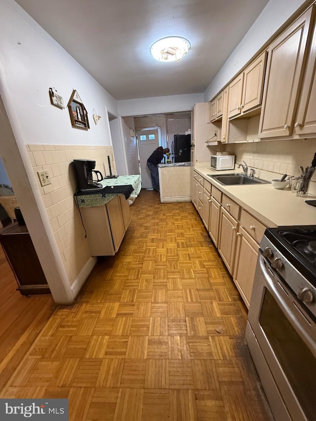 332 Emerson St NW, Washington, DC 20011 - kitchen with light brown cabinets, a sink, stainless steel gas range oven, and white microwave