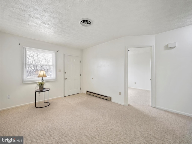 interior space with a baseboard heating unit, baseboards, a textured ceiling, and visible vents