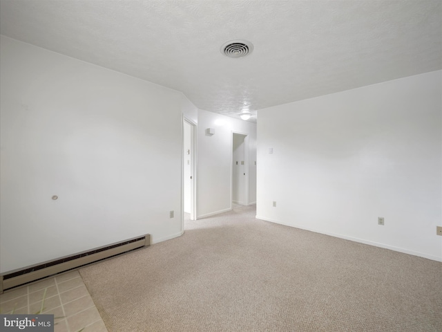 carpeted spare room with visible vents, a textured ceiling, baseboards, and a baseboard radiator