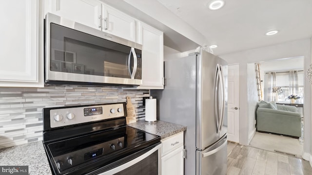 kitchen featuring light wood finished floors, stainless steel appliances, recessed lighting, decorative backsplash, and white cabinets