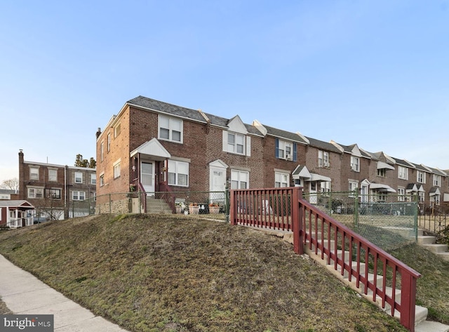 multi unit property featuring brick siding, fence, and a residential view